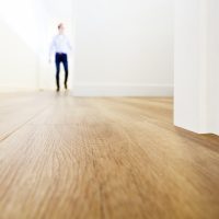 Man loopt over een prachtige houten vloer